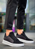 Black sneakers with white soles worn by a person on a blurred background